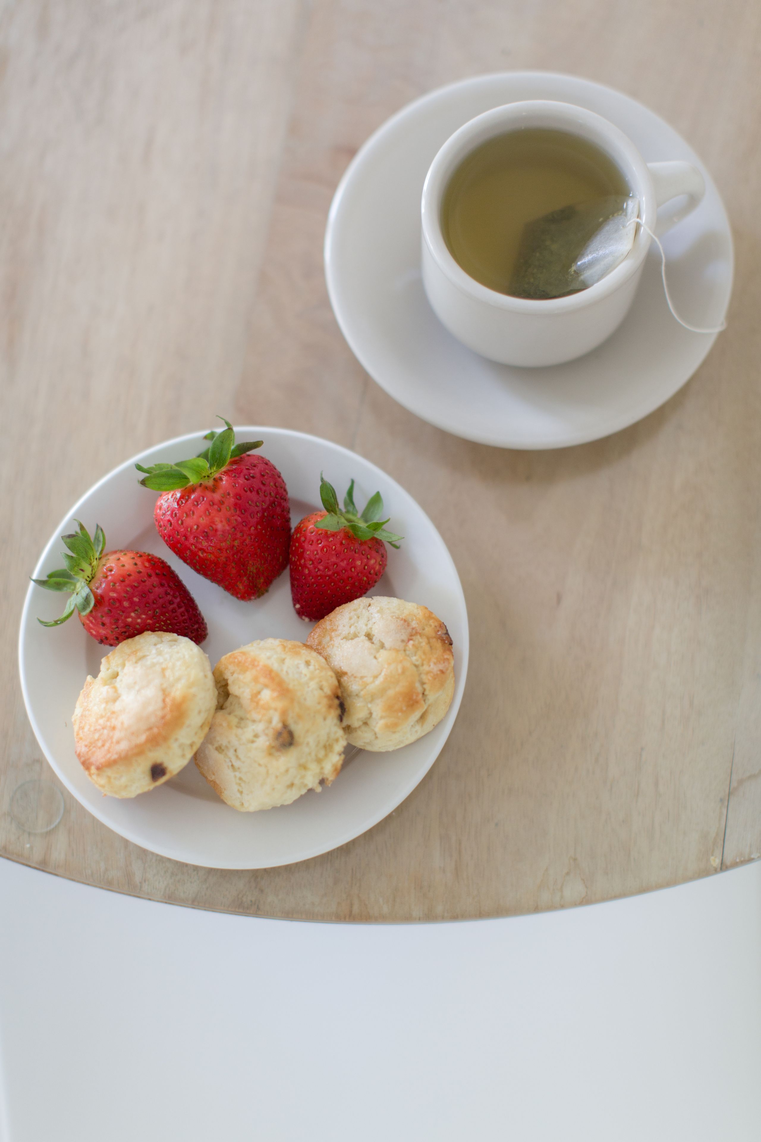 Un plato con fresas y galletas sobre una mesa.