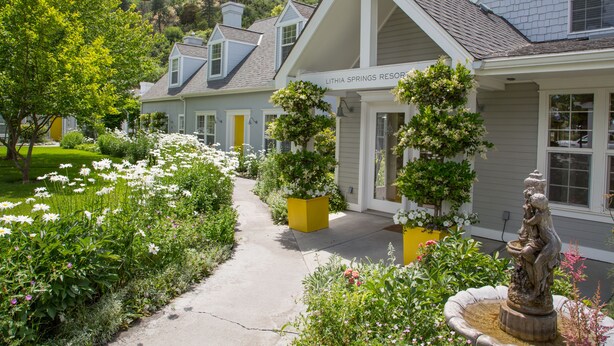 A resort with a covered walkway, potted plants, and a statue. - Lithia Springs Resort (Ashland)