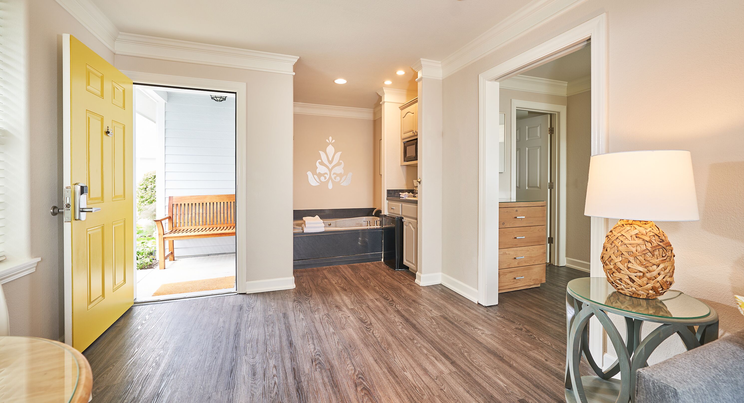 A modern kitchen with dark wood flooring, a built-in oven, and a microwave.