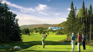 Un terrain de golf avec un club-house en arrière-plan.