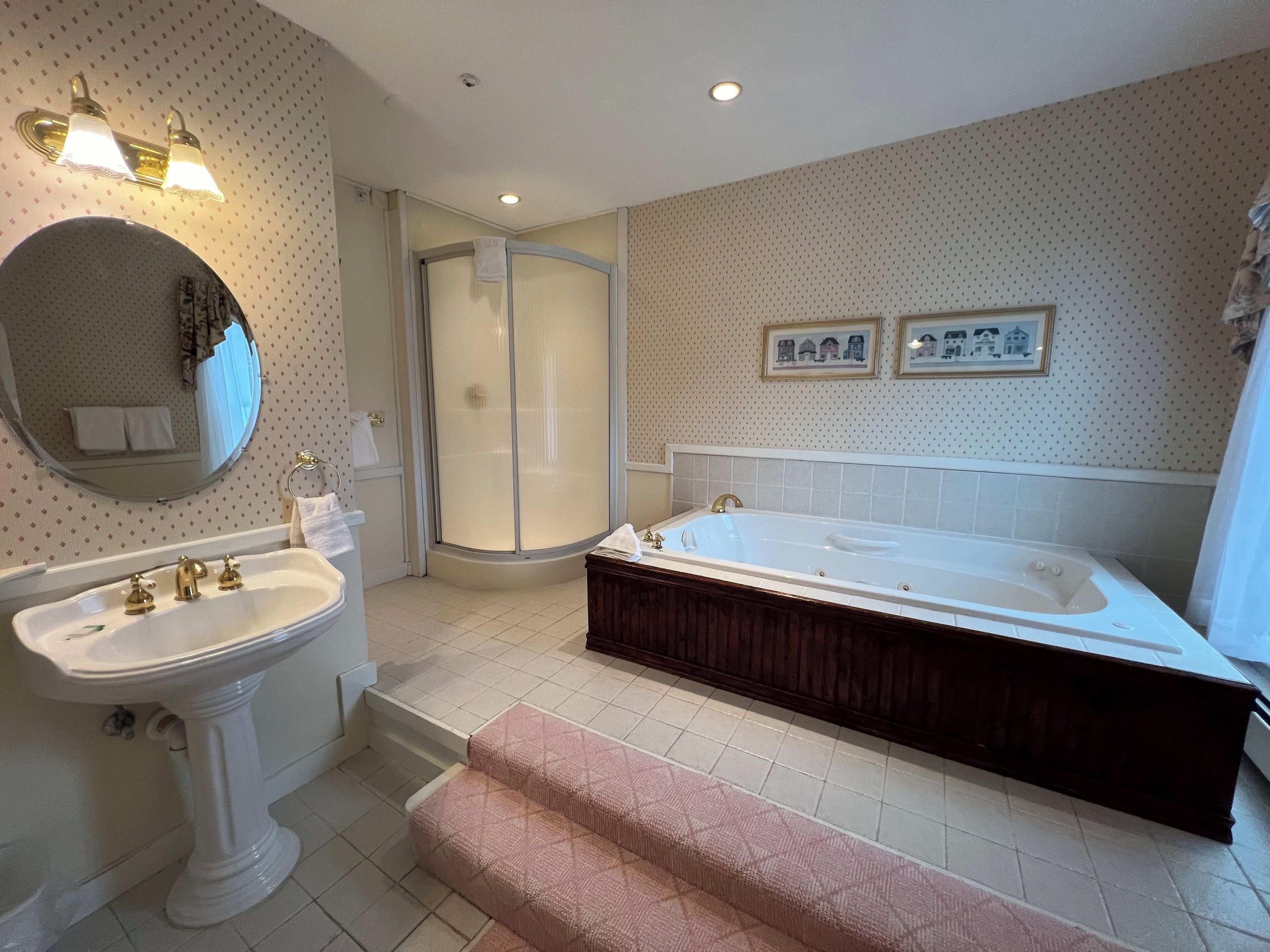 A bathroom with a sink, mirror, shower, and bathtub.