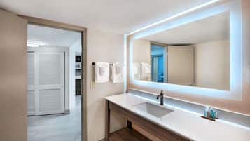 Un baño moderno con un espejo grande, un lavabo y un perchero para toallas.