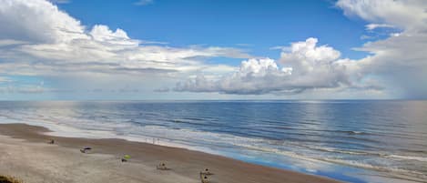 A beach with a clear sky and a few umbrellas.