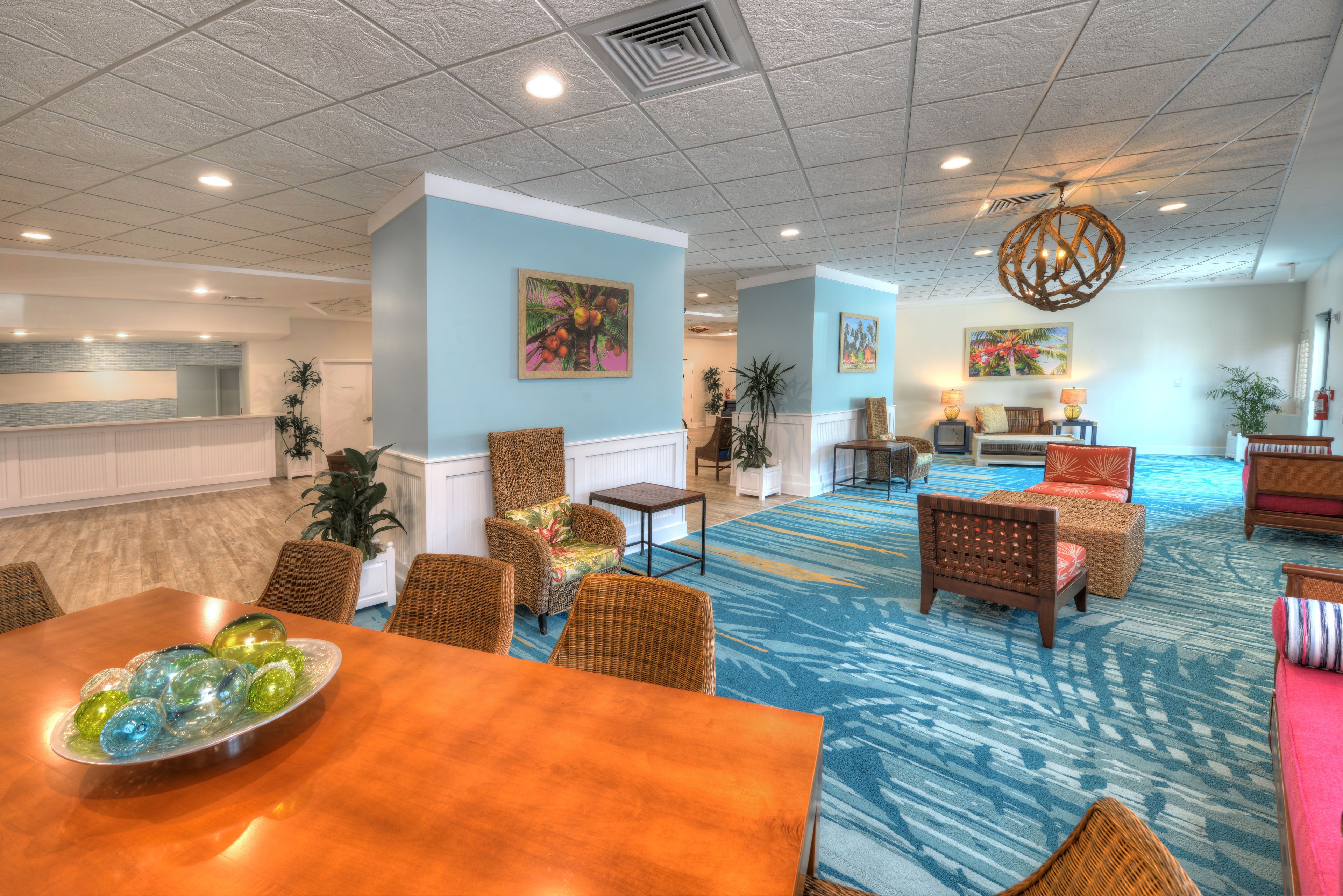 A spacious lobby with a reception desk, comfortable seating areas, and a blue patterned carpet.