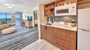 A modern kitchen with wooden cabinets, a microwave, and a coffee maker. - Bahama House (Daytona Beach Shores)