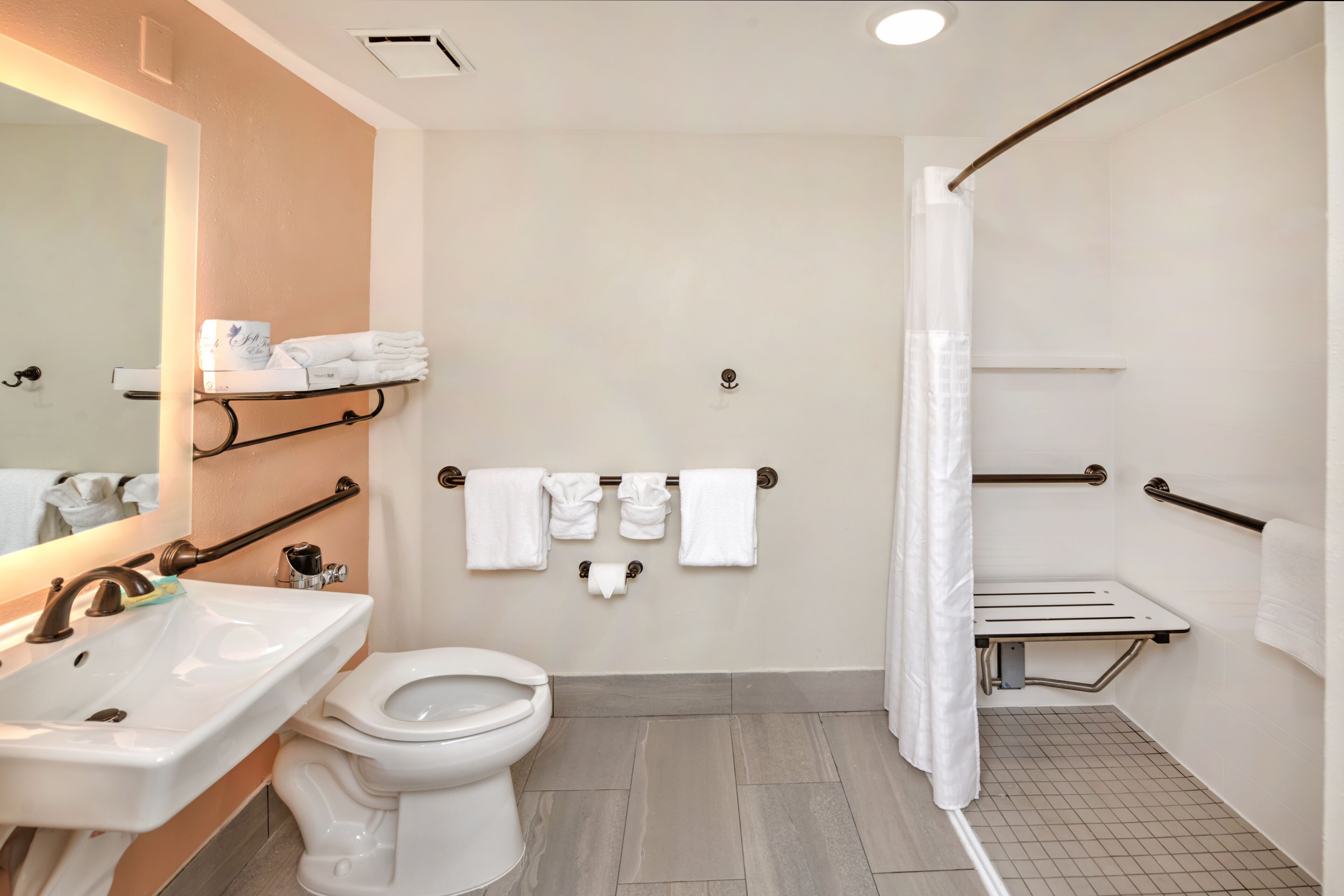 A modern bathroom with a sink, toilet, and shower area.