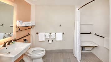 Un baño moderno con lavamanos, inodoro y zona de ducha.