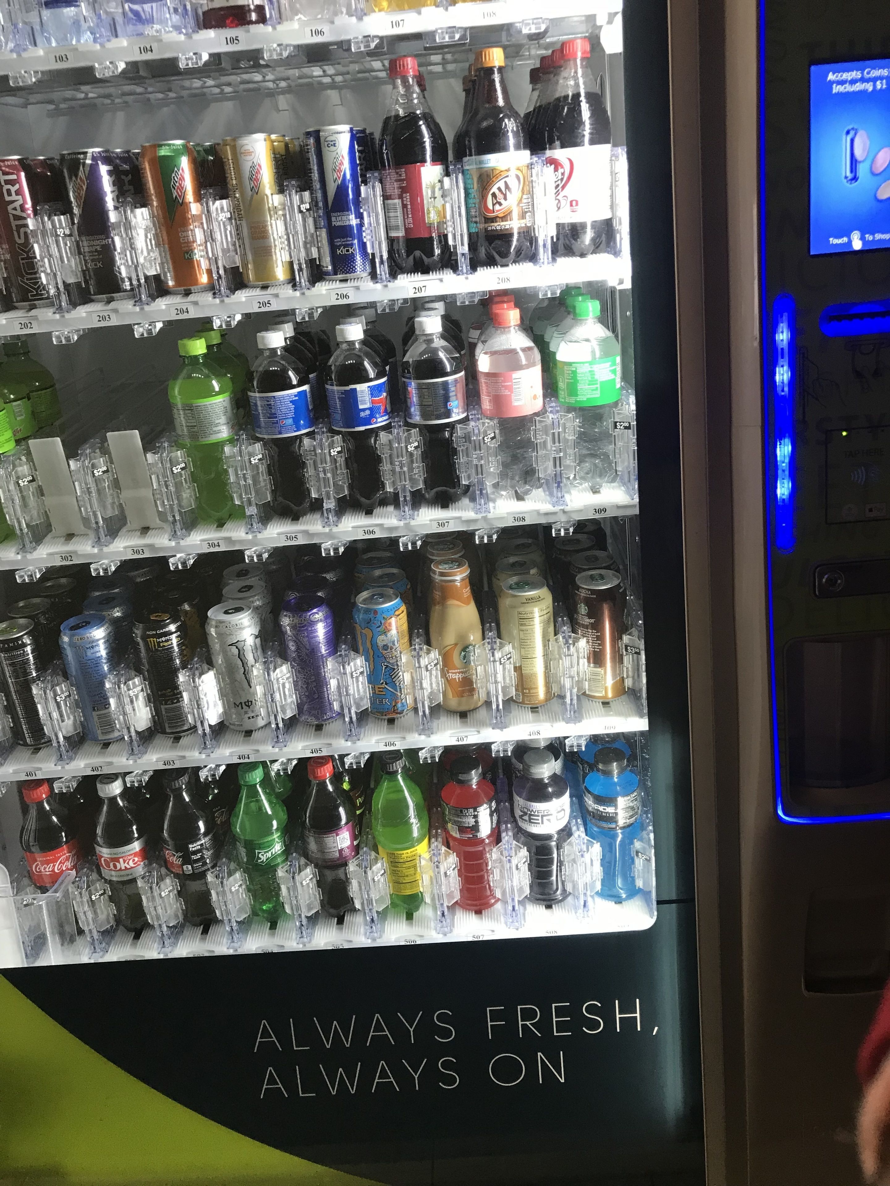 A vending machine stocked with various beverages including sodas, energy drinks, and water.