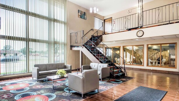 Un vestíbulo amplio con una escalera, un sofá y una mesa de centro.