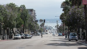 Une vue de rue avec des voitures garées, des arbres et des bâtiments.