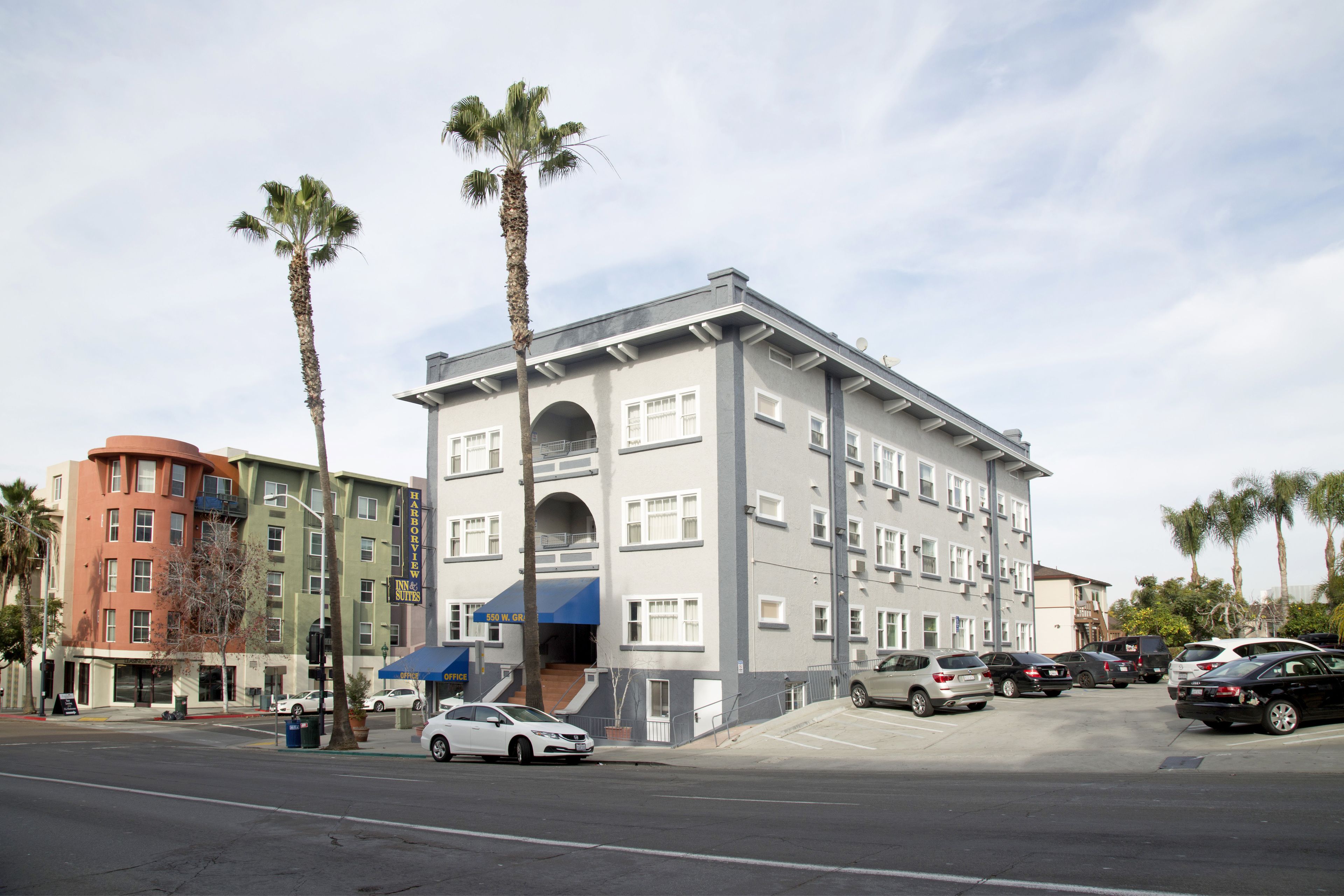 A multi-story hotel with a modern architectural design, featuring a prominent entrance with a blue awning and a visible outdoor seating area.