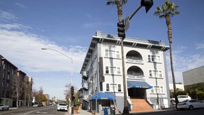 Un immeuble à plusieurs étages, doté d’un auvent bleu sur lequel on peut lire le mot « Bureau » et d’une enseigne indiquant « 550 W. Grape ».