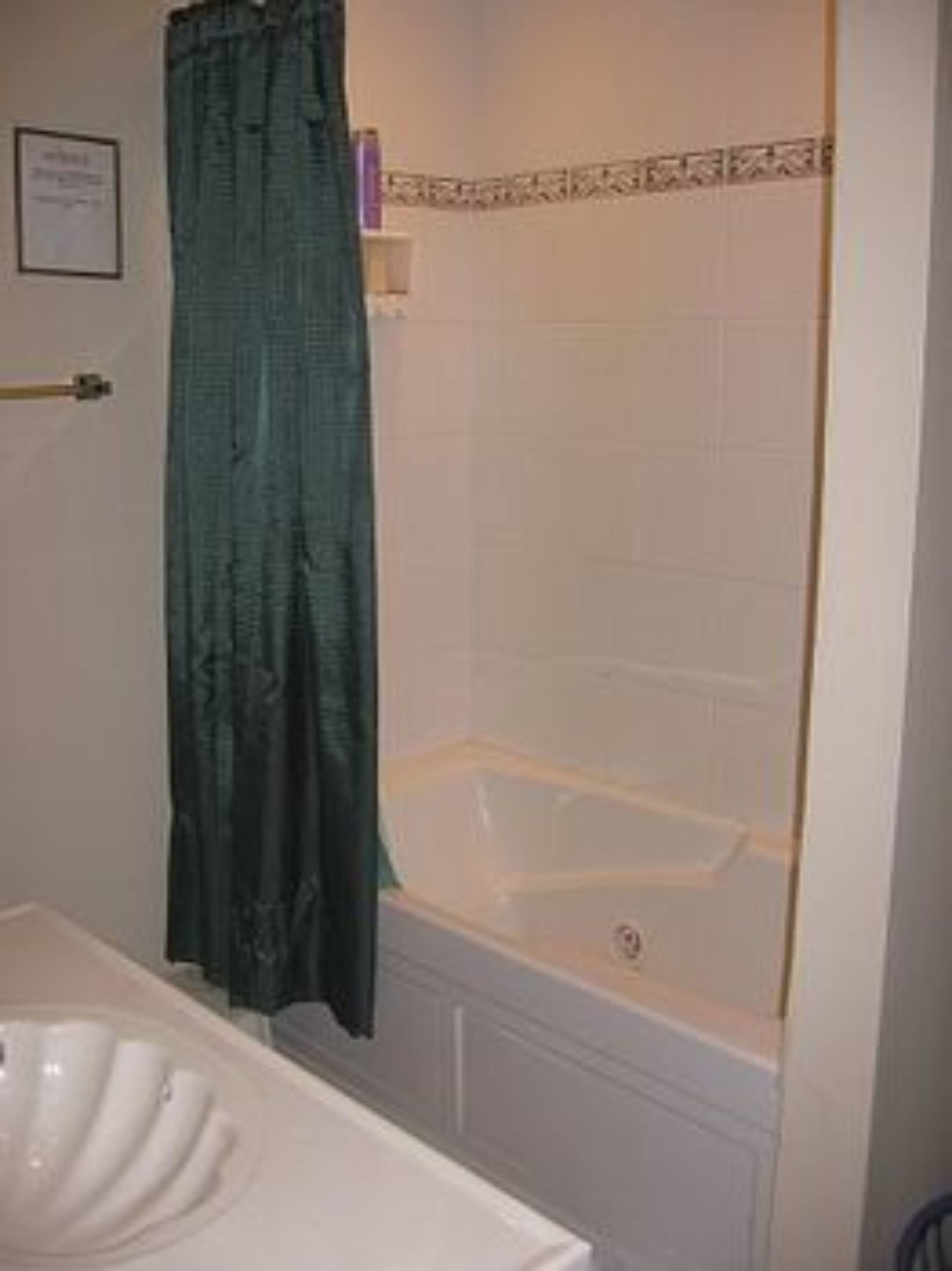 A bathroom with a bathtub, a sink, and a shower curtain.
