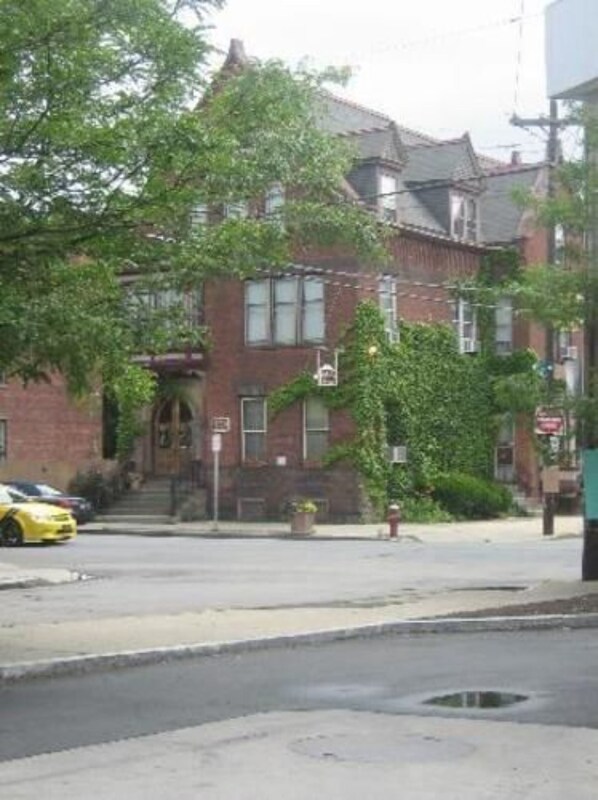 A brick building with a traditional design, featuring a front entrance with steps and a small porch.