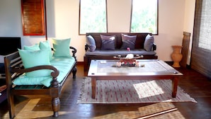 Una sala de estar con un sofá, una mesa de centro de madera y una alfombra estampada.