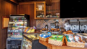 A breakfast bar with a variety of food items, beverages, and a coffee machine.