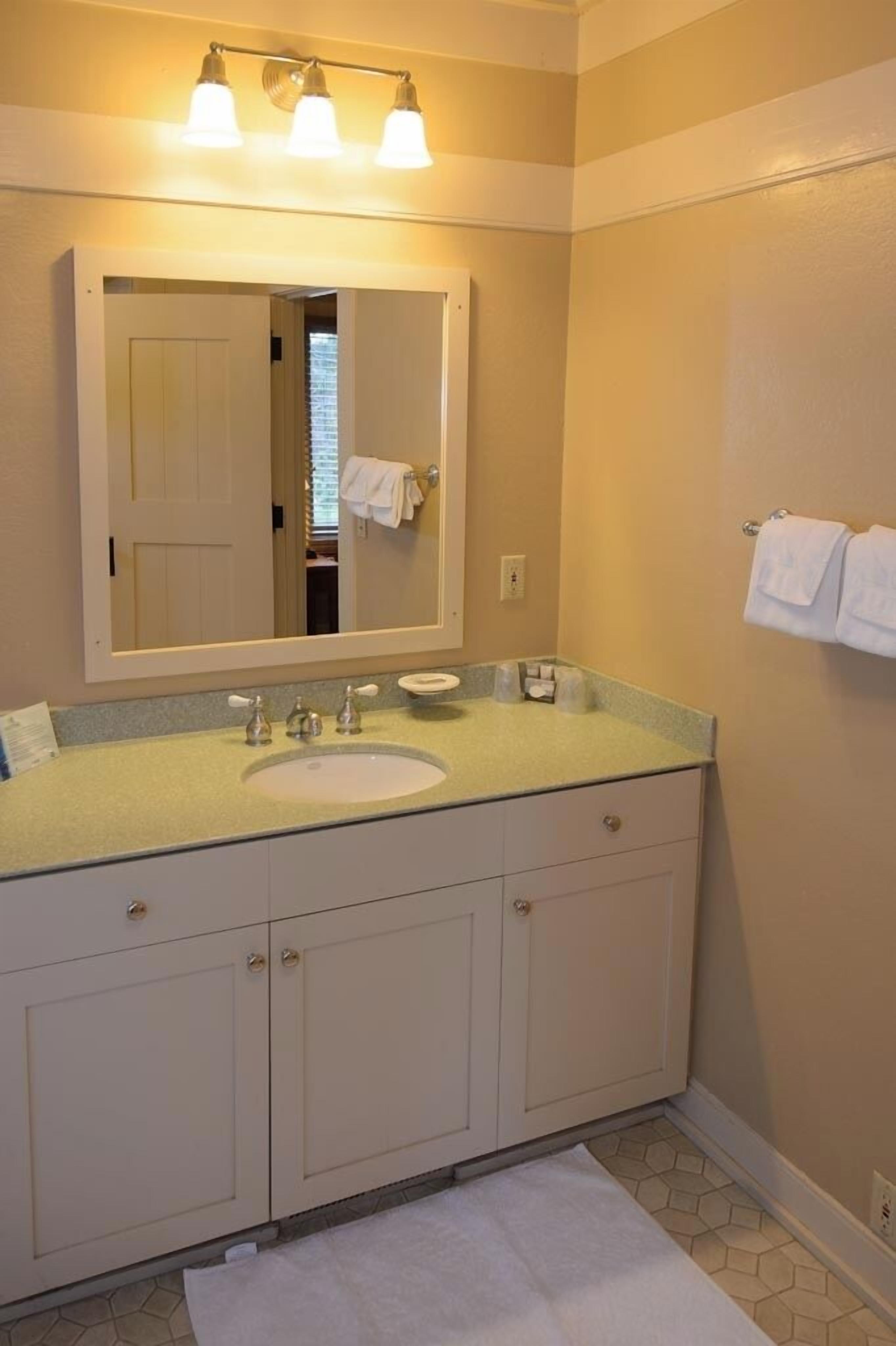 Une salle de bain équipée d’un lavabo, d’un miroir et d’un porte-serviettes.