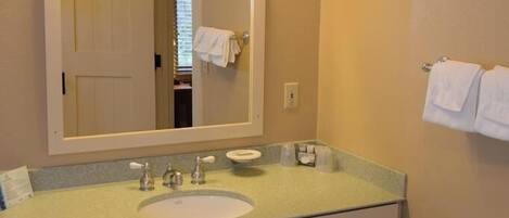 Une salle de bain équipée d’un lavabo, d’un miroir et d’un porte-serviettes.