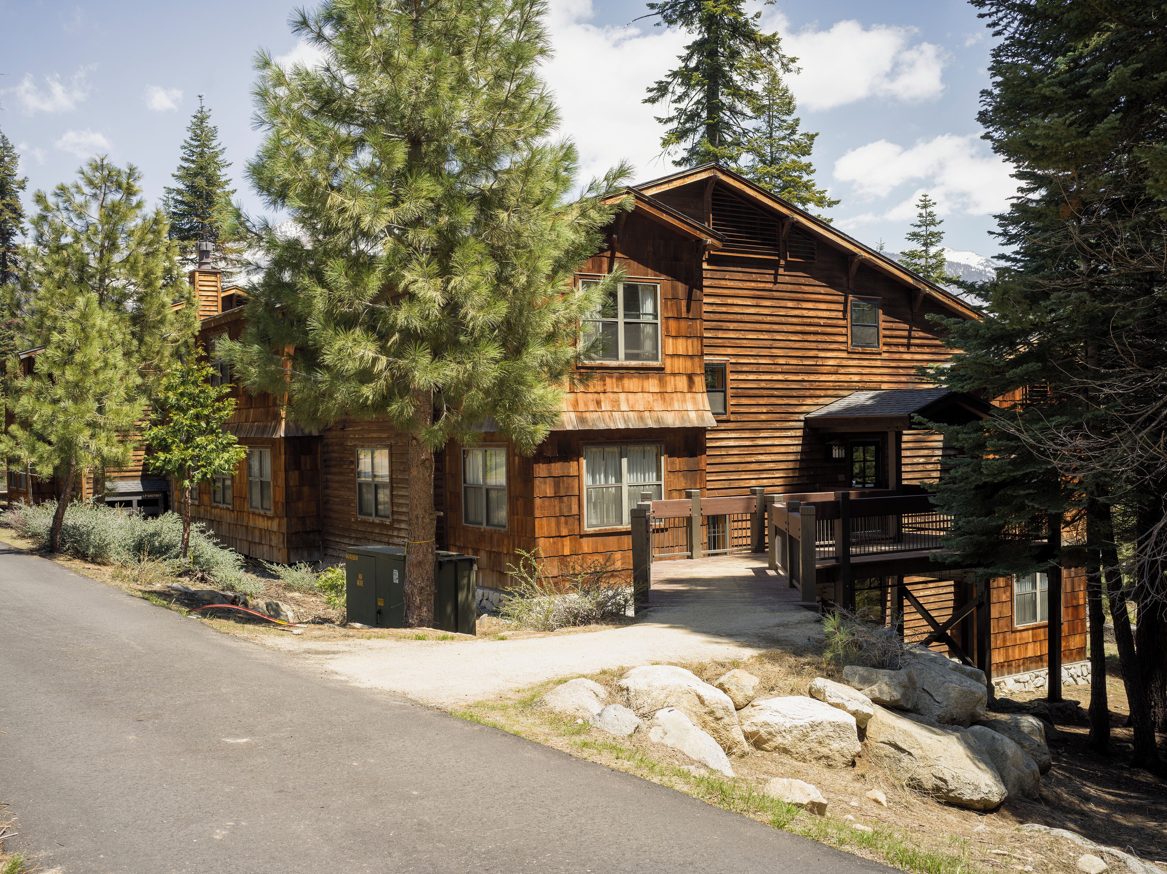 Eine rustikale Holzhütte mit Veranda, großen Fenstern und einer Terrasse.