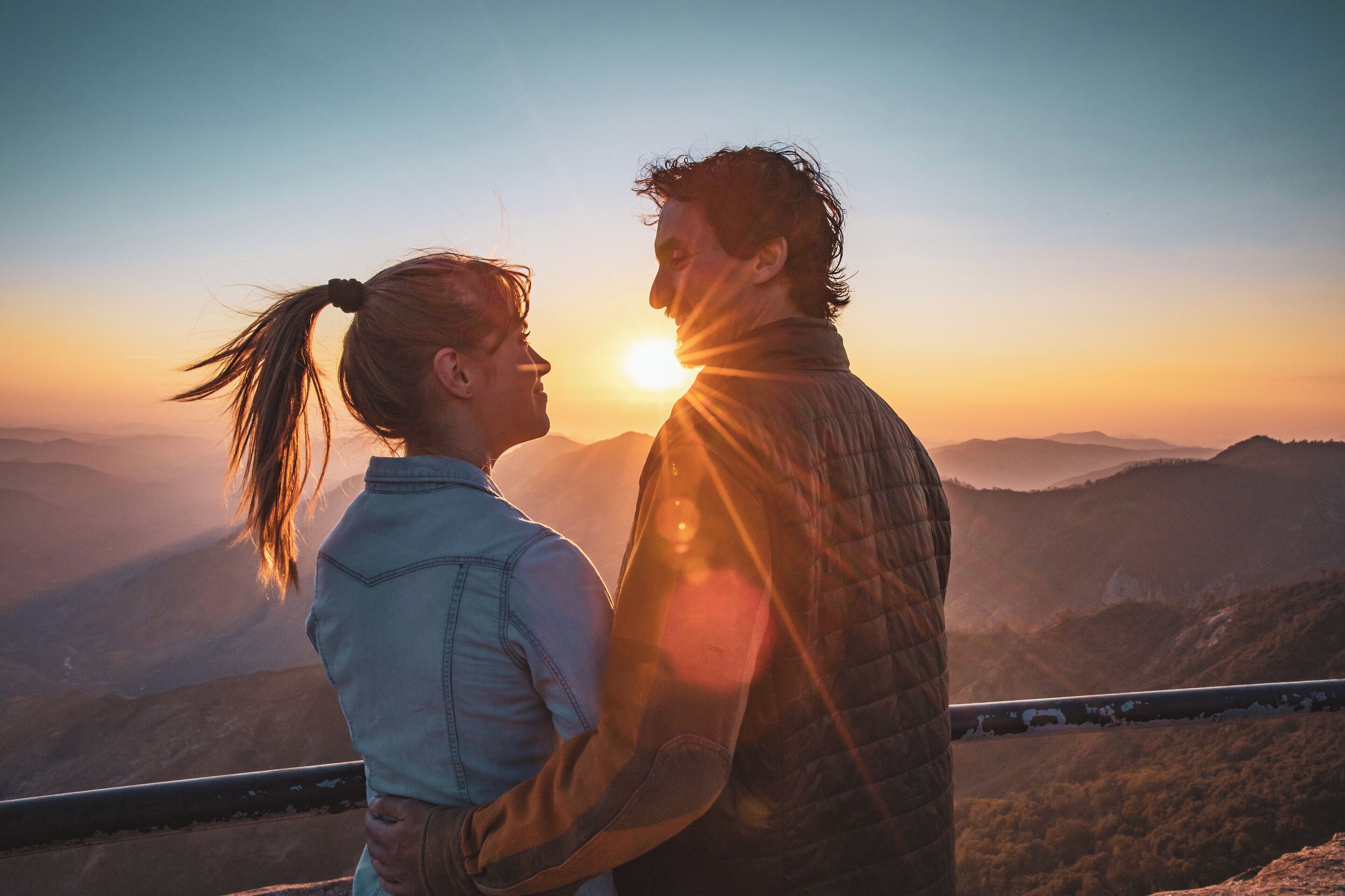 A couple embracing with a sunset in the background.