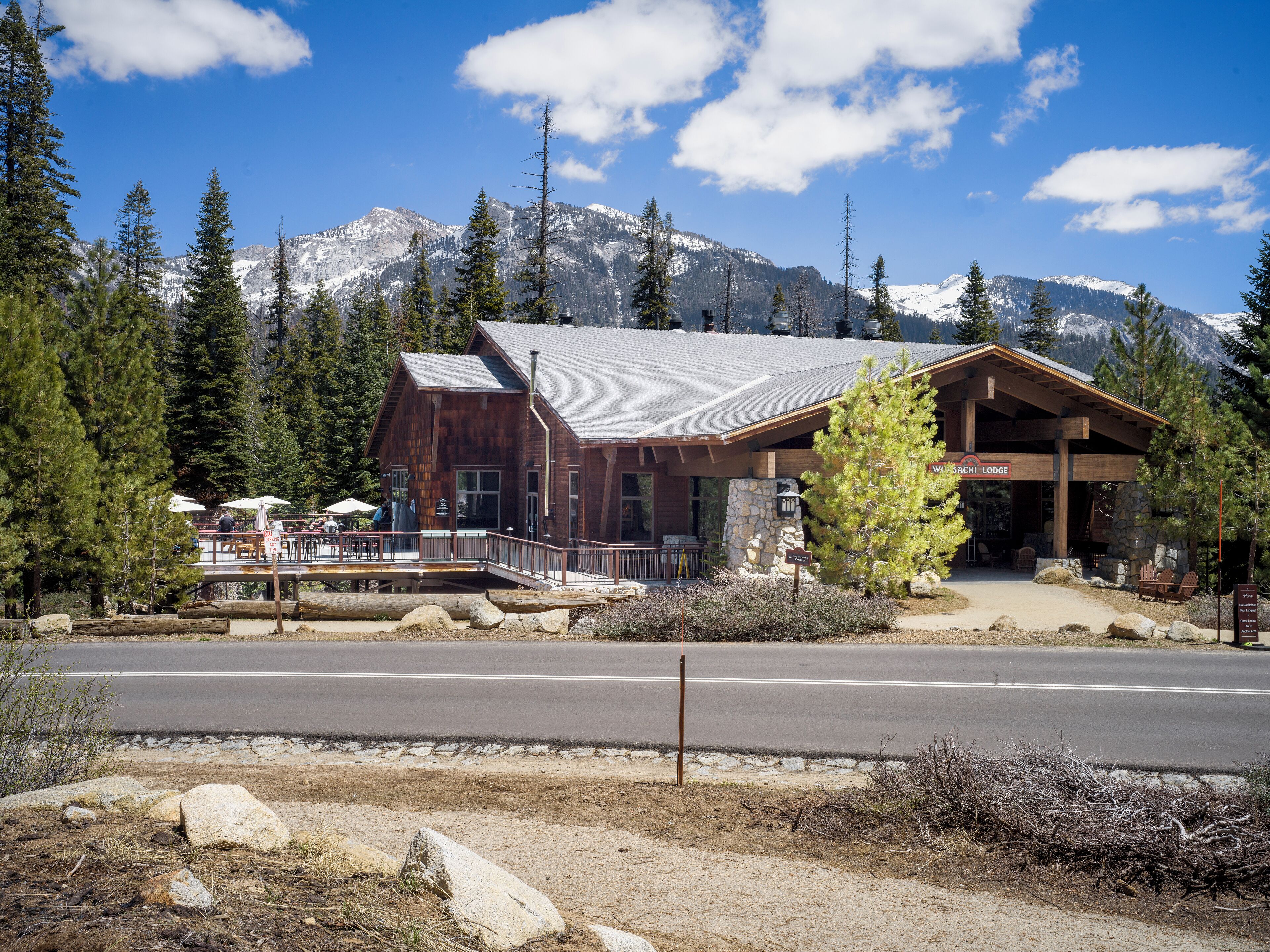 A lodge with a stone foundation, wooden exterior, and a covered entrance.