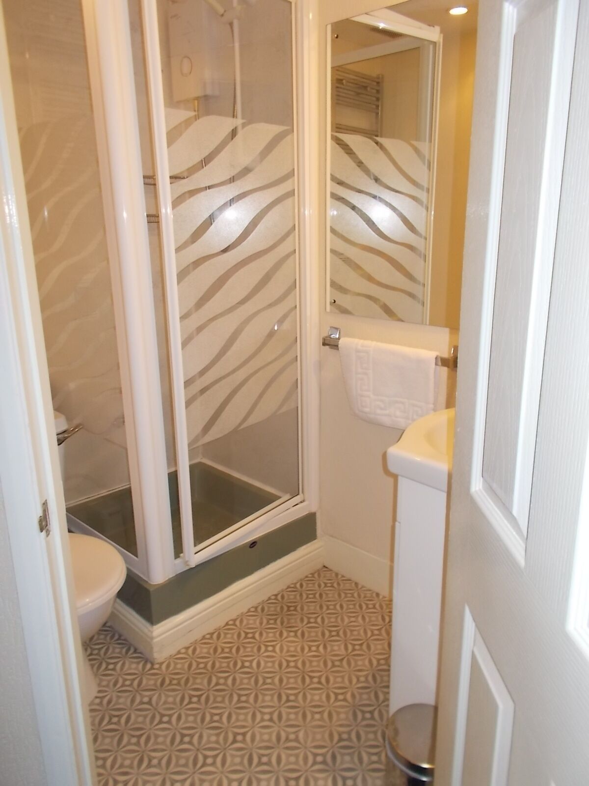 Baño con ducha, inodoro y lavabo.