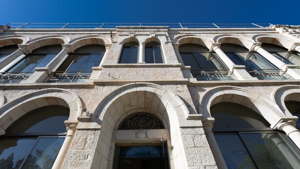 Un edifici amb diverses finestres d'arc i una entrada central amb un arc decoratiu.