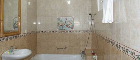 A bathroom with a sink, bathtub, and shower.