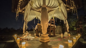 A gazebo with draped fabric, a statue, and candle-lit tables. - Cendana Resort & Spa (Ubud)