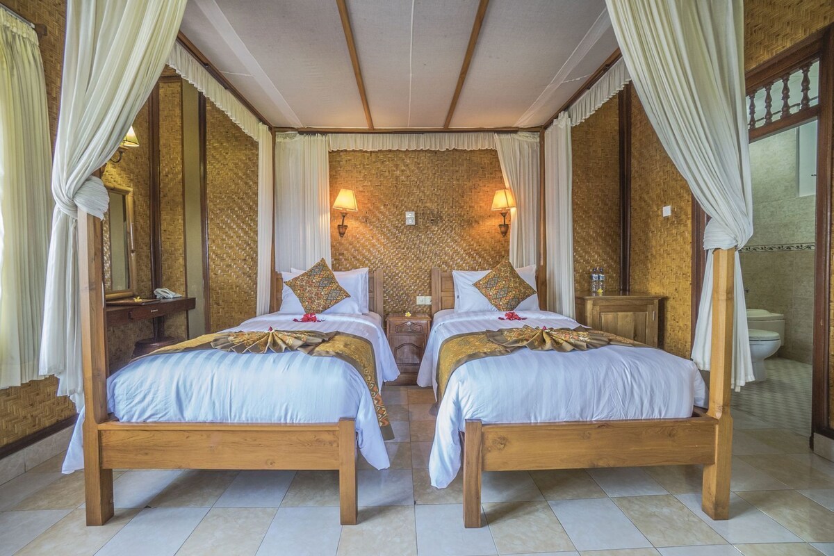 A room with two wooden beds, a large mirror, and a woven wall.
