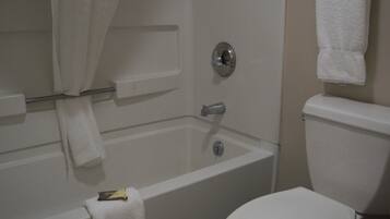 A bathroom with a bathtub, toilet, and a towel rack.