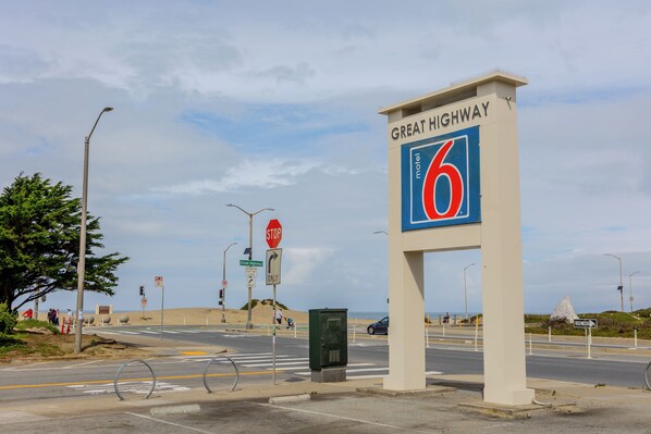A motel sign with the number 6, a stop sign, and a one-way sign at a roadside intersection. - Motel 6 San Francisco, CA – Great Highway (San Francisco)