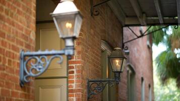 A brick building with a door and two wall-mounted lantern-style lights.