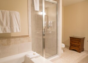Bathroom features a glass-enclosed shower, bathtub, and vanity with a mirror.