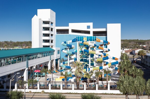A water park with multiple slides and a building with balconies.