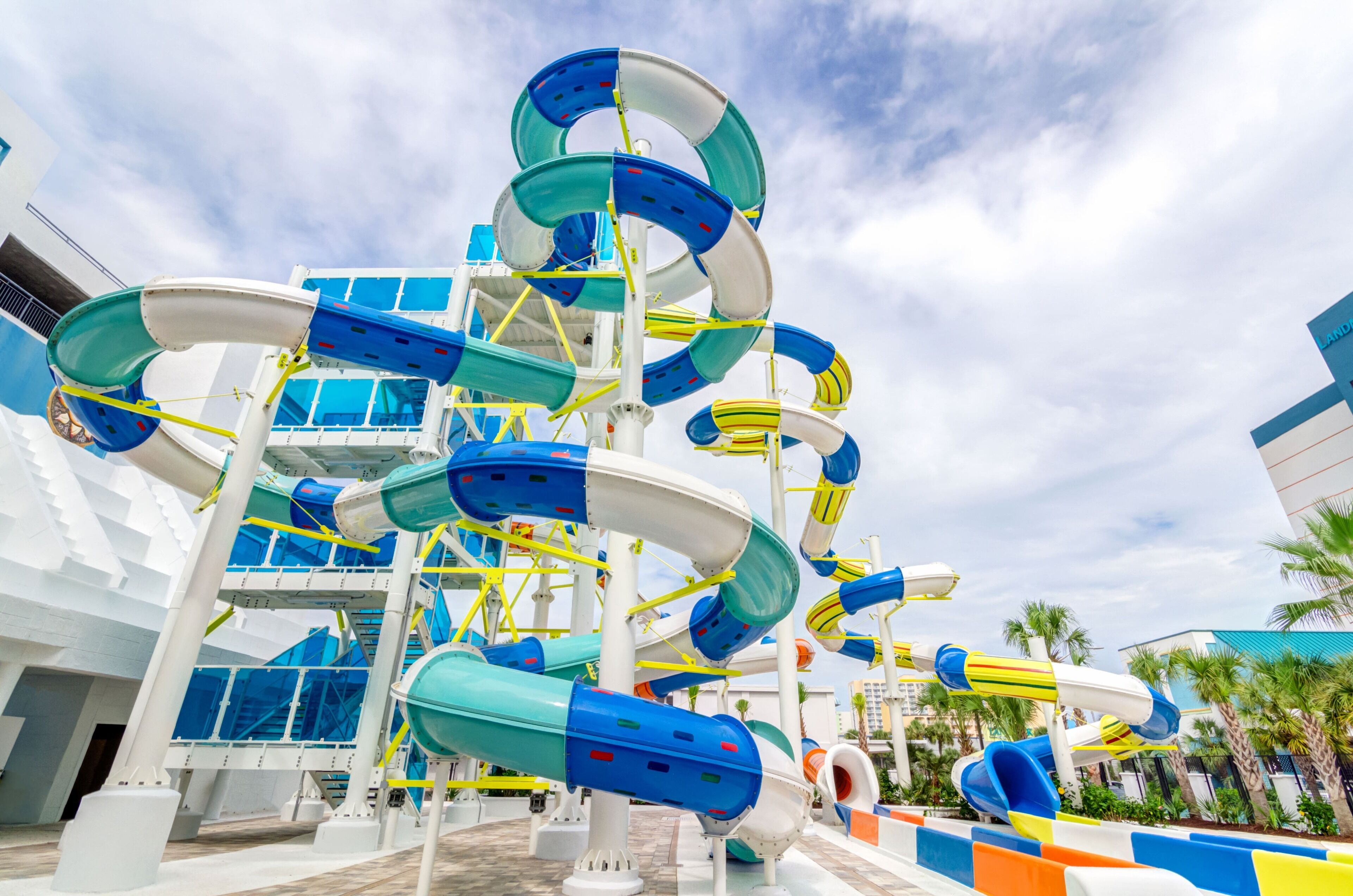 A water park with multiple water slides and a white building structure in the background.