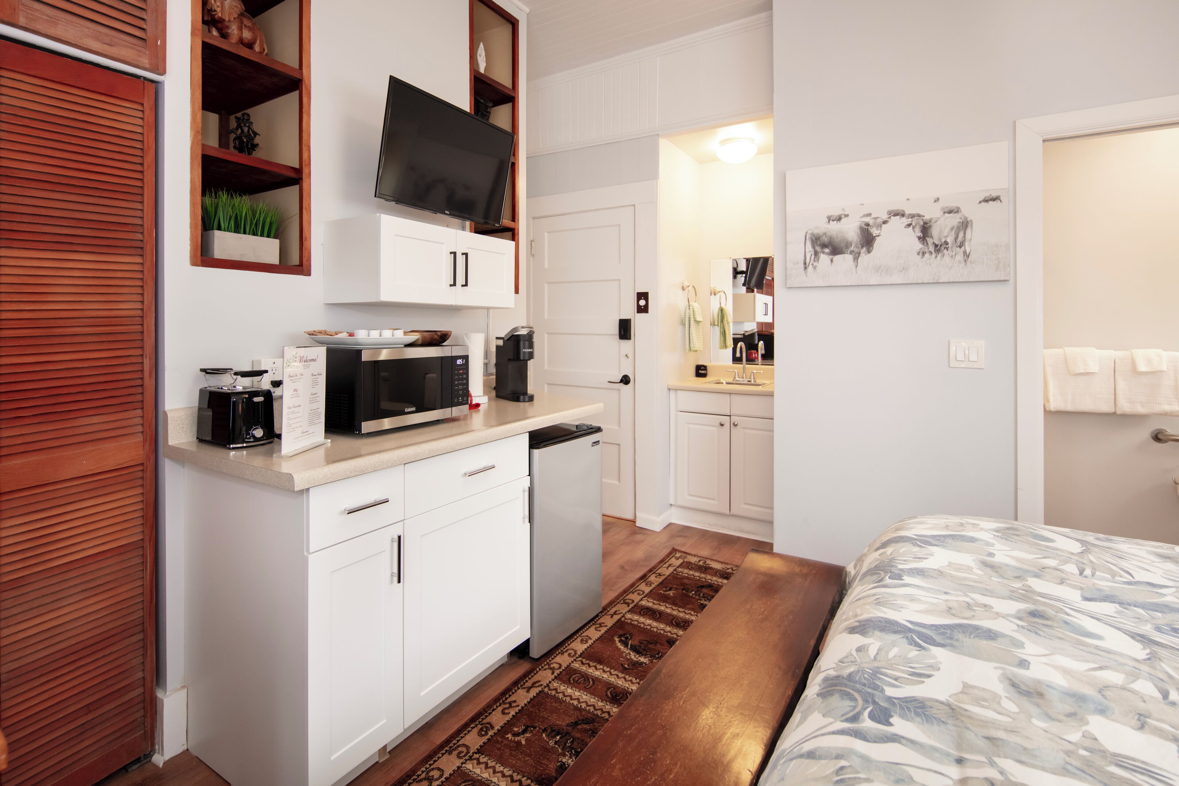 A compact kitchen with a microwave, coffee maker, and a small refrigerator.