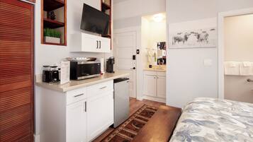 A compact kitchen with a microwave, coffee maker, and a small refrigerator.