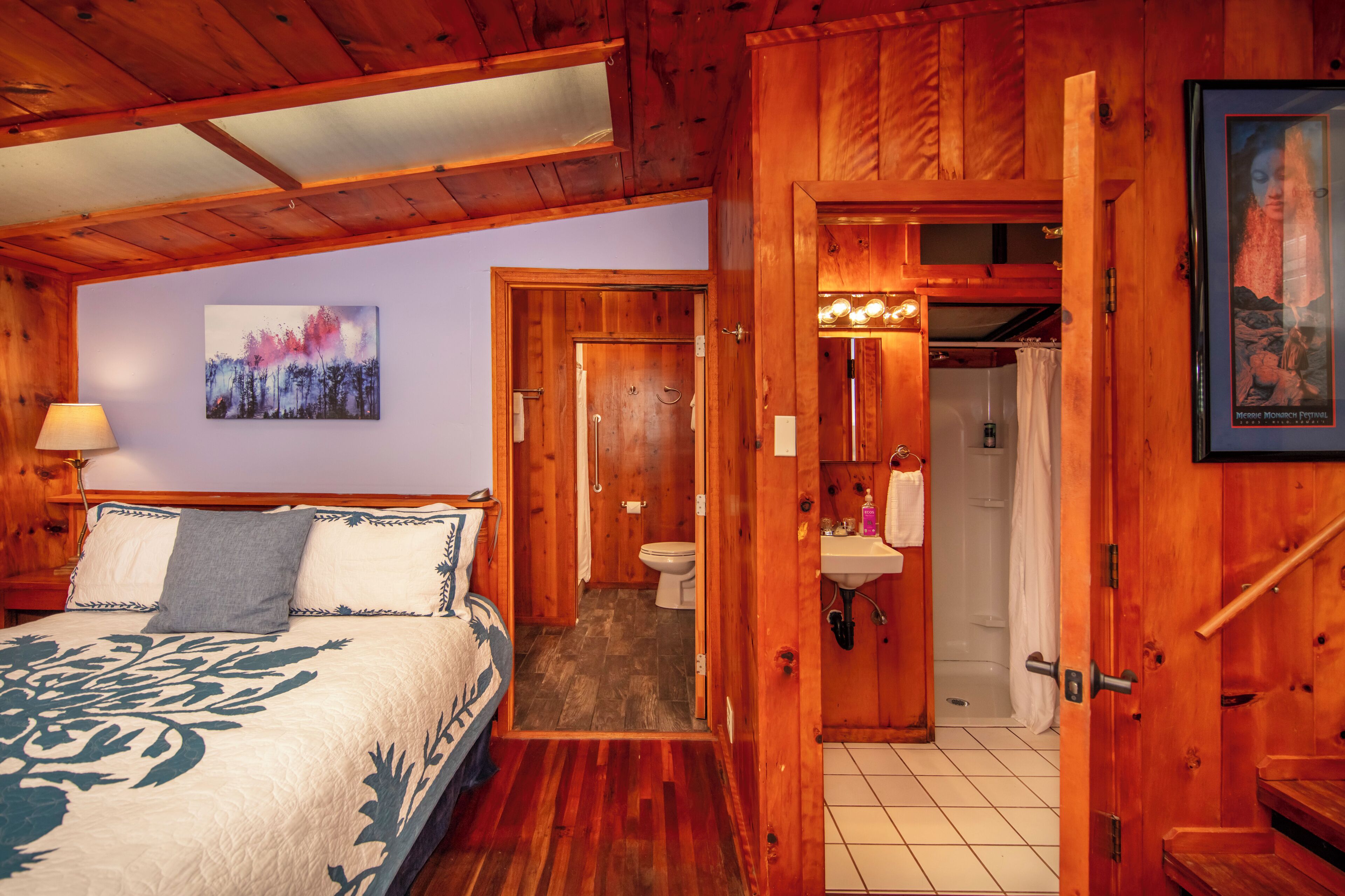 Una habitación de madera con cama, baño y ducha.