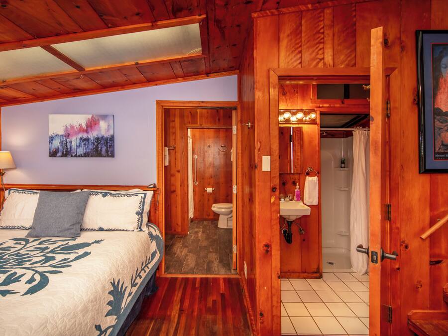 Une pièce en bois avec un lit, une salle de bain et une douche.