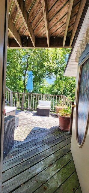 A wooden deck with outdoor furniture, a blue umbrella, and potted plants. - Bridgeford House Bed and Breakfast (Eureka Springs)