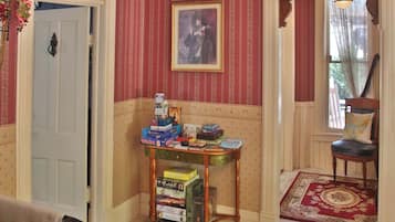 A room with striped wallpaper, a table with board games, a chair, and a door labeled "Nottinghamshire".