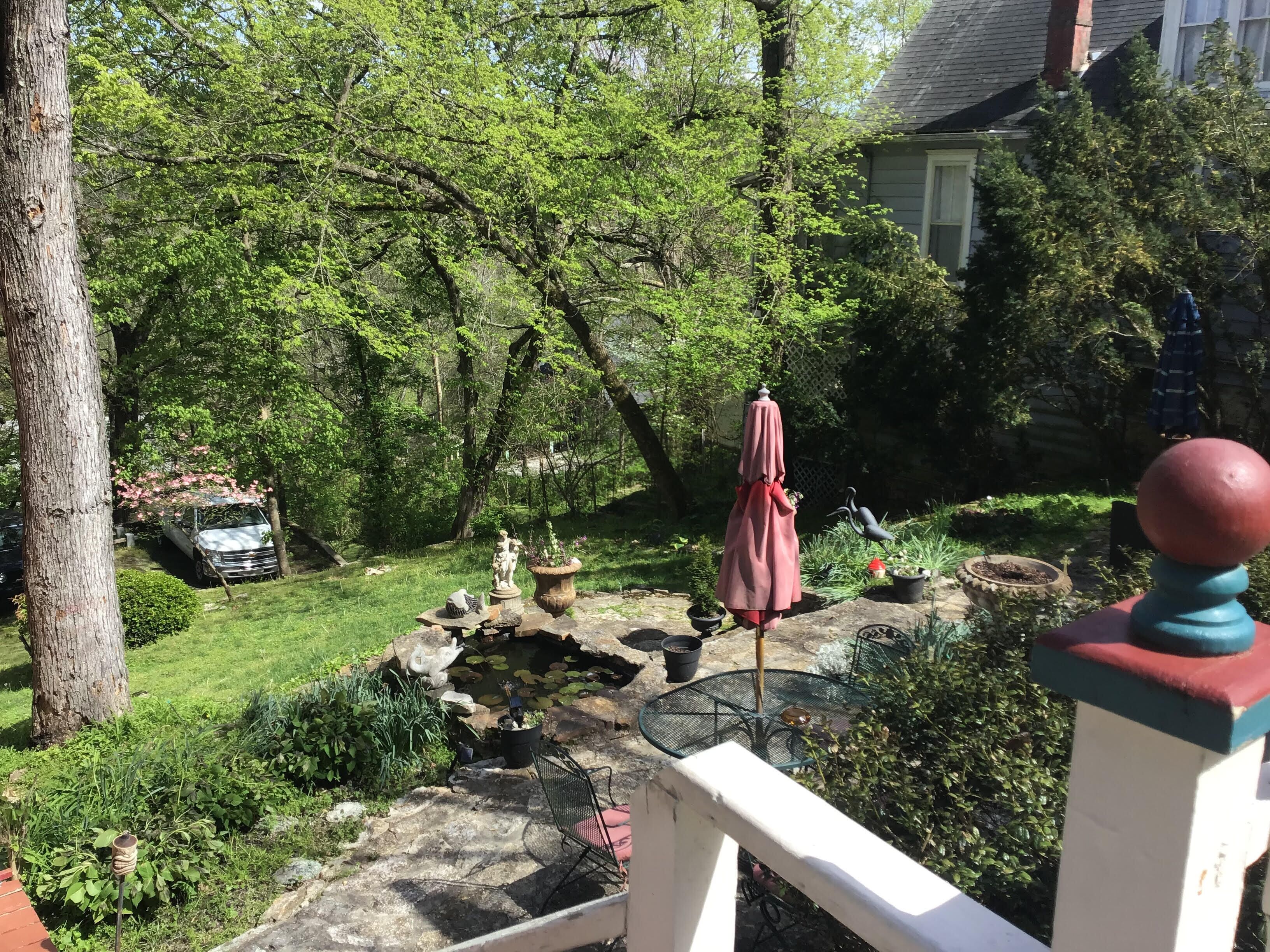A garden with a pond, a table, and chairs.