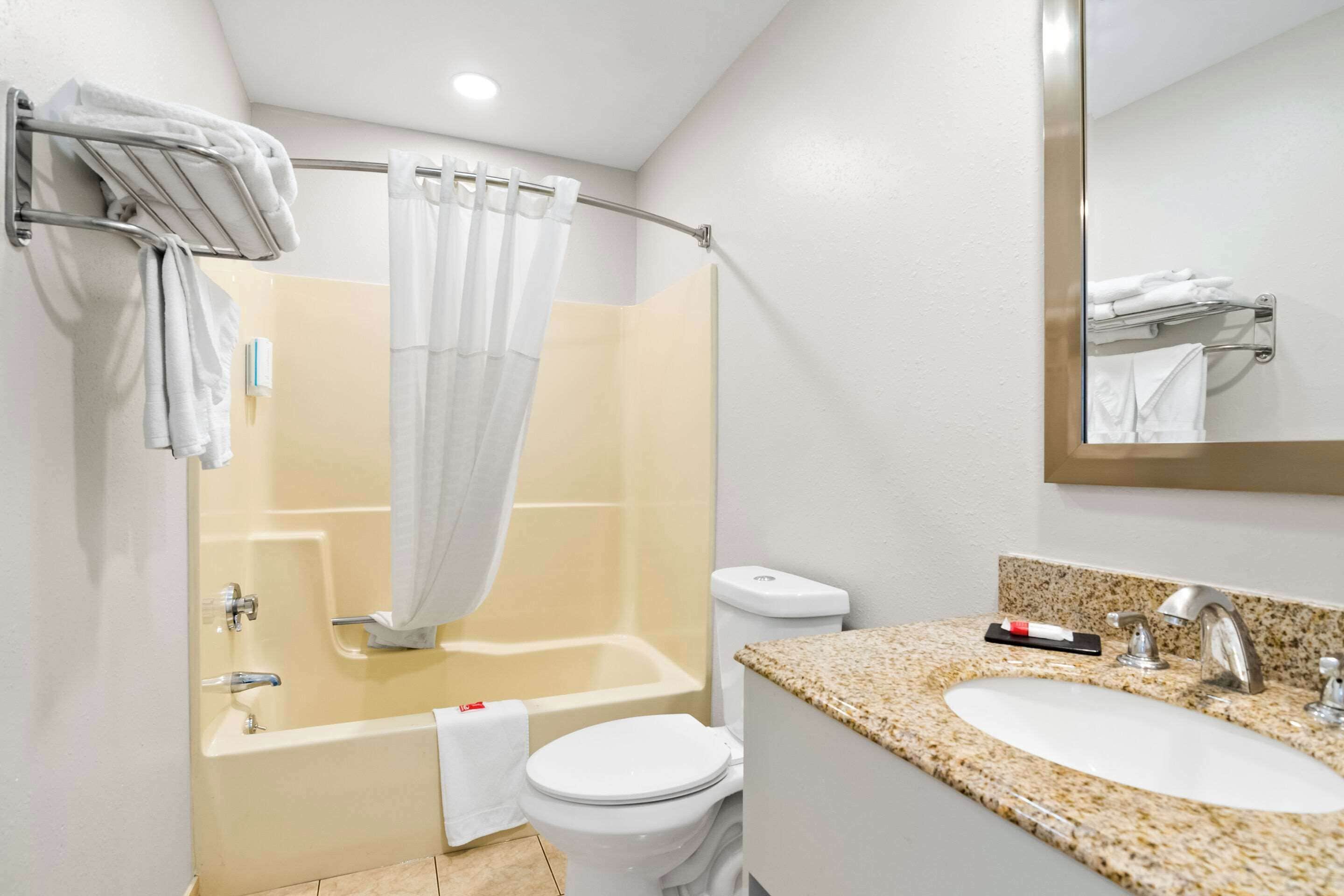 A bathroom with a bathtub, toilet, and sink.