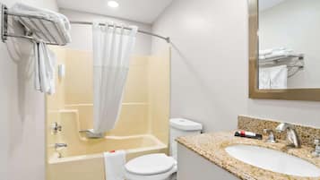A bathroom with a bathtub, toilet, and sink.
