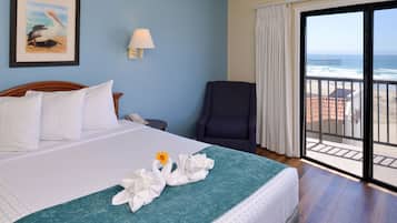 Ein Hotelzimmer mit einem Bett, einem Sessel, einem Gemälde und Meerblick.