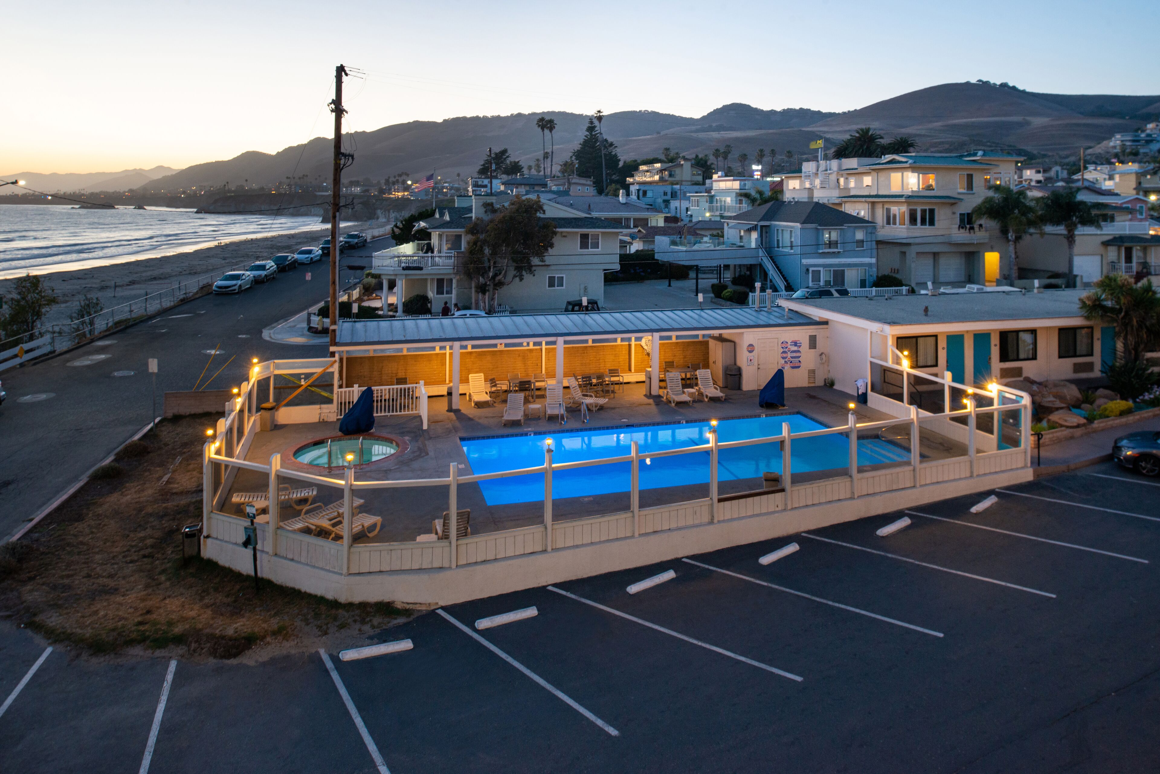 Ein Hotel mit Pool, Außenbereich und Blick auf den Strand.