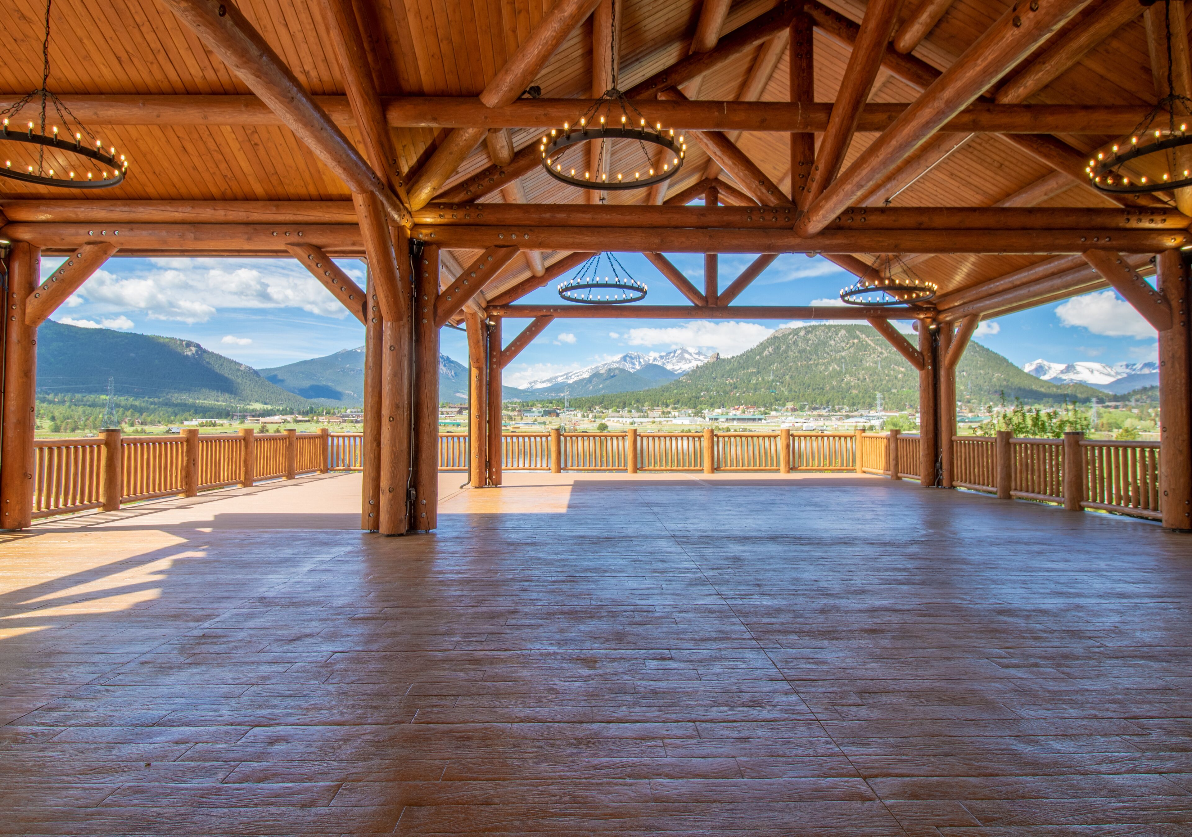 Een ruim houten paviljoen met uitzicht op bergen en een heldere lucht.