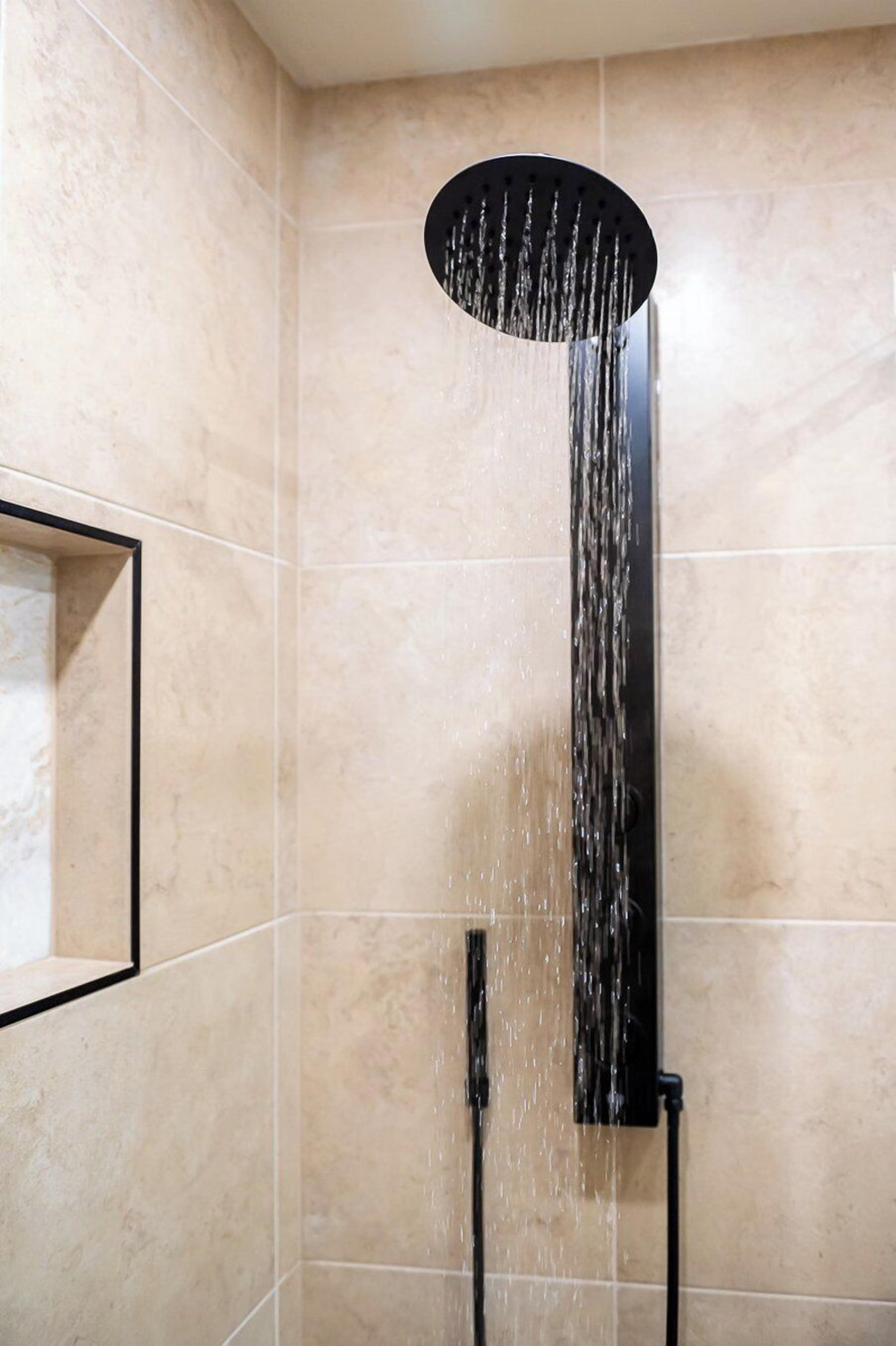 A shower with a circular head and water flowing down.