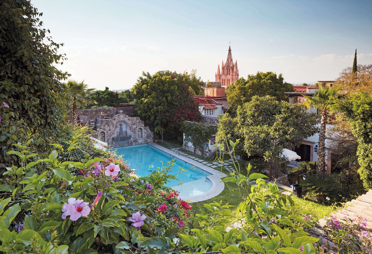 Pool area of Belmond Casa de Sierra Nevada surrounded by a beautiful garden overlooking the cathedral